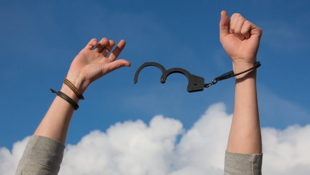 Photo of a person tipping off handcuffs to represent how PTSD symptoms hold you back but trauma therapy and PTSD treatment can help you break free. Our psychologists offer trauma therapy & PTSD treatment to anyone in the state of Florida.