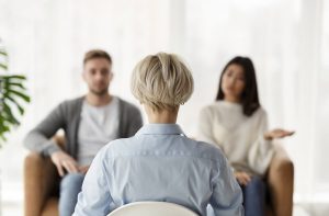 An image of a couple sitting in seprate chairs across from an attentive therapist. This could represent meeting with a marriage counselor in Tampa, FL to work out relationship issues. Contact a marriage counselor to learn more about our services including discernemnt counseling in Tampa, FL and more! 33609 | 33704 | 33703 