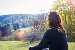 A woman sits while looking off into the distance on a sunny day. Learn how DBT in St. Pete, FL can help you gain peace. A DBT therapist in St. Pete, FL can offer support in Tampa, FL and across the state!