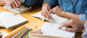 A close-up of people writing in books, representing the support psychoeducational testing in Tampa, FL can offer. Learn more about psycho-educational testing in Tampa, FL, and other services offered by Wellness Psychological Services. 