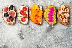 A top down view of 4 bread snacks with different toppings. This coulld represent feeling more comfortable with food after workign with an eating disorder therapist in St. Pete, FL. Learn more about eating disorder treatment in Tampa, FL and the support an online eating disorder therapist in Tampa, FL can offer.