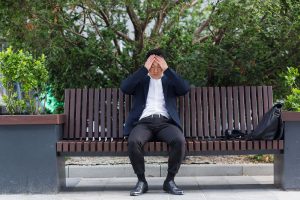 A person sits on a park bench while holding their head. This could represent an anxiety attack in a park. Learn how counseling for anxiety in Tampa can offer help by searching for anxiety therapy in Tampa, FL today. Or, contact a therapist Tampa, FL to learn more.
