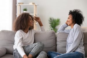 A mother sits while smiling and talking to her teen daughter. This could represent the support offered from anxiety treatment in Tampa, FL. Learn how a therapist in Tampa, FL can offer support with thoughts by searching for online anxiety treatment in Florida and other services. 