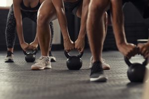 A group stands in a line with dumbbells as they workout. Learn how exercise can offer support with addressing anxiety by searching for online anxiety treatment in Florida or contacting a therapist in St. Pete. They can offer counseling for anxiety in Tampa and online anxiety treatment in Florida. 