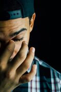 a close up of a guy with his hand on his face struggling with anxiety, anxiety and behavioral health services, anxiety therapy